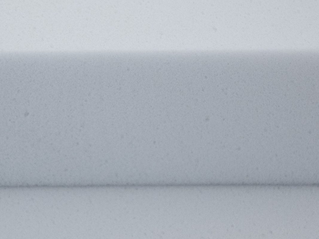 Gros plan sur la mousse de mélamine Basotect G+ gris clair - un chant coupé avec la structure à cellules ouvertes visible