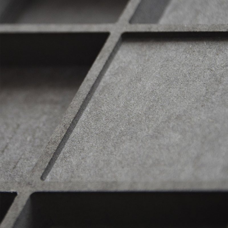 Gros plan sur la surface noire en relief du diffuseur QRD