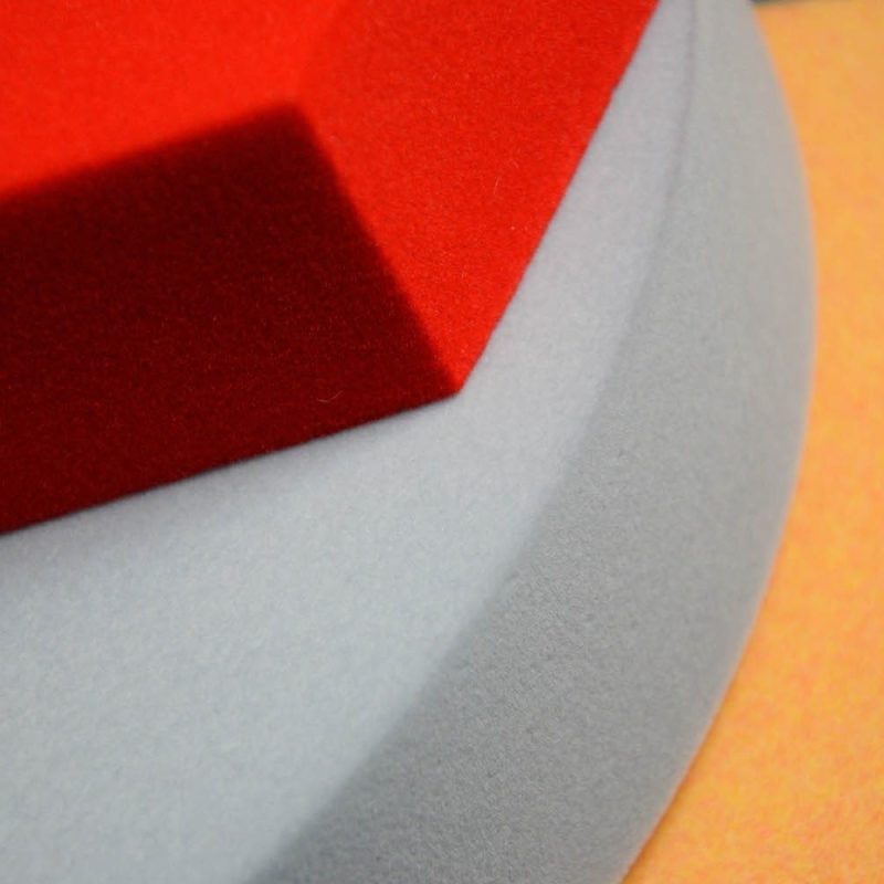 Gros plan sur la surface floquée des panneaux Foamly en trois couleurs - rouge, gris et orange